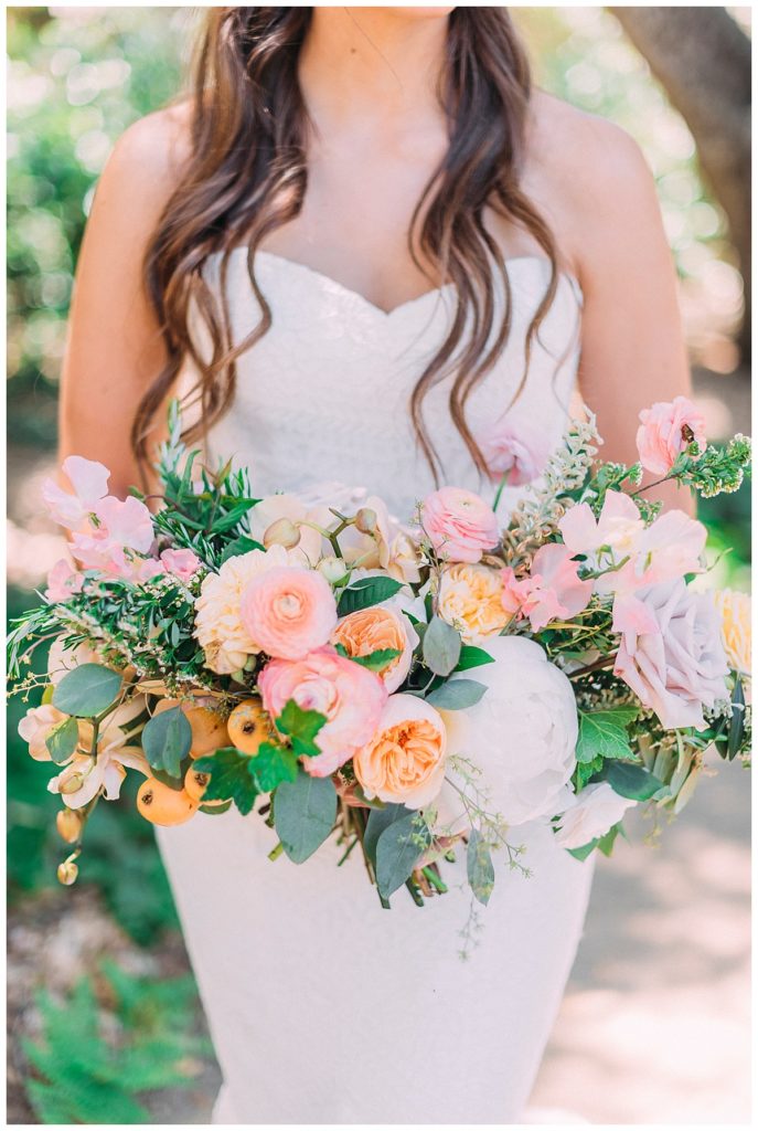 Peach, pink, and white wedding bouquet with greenery. 